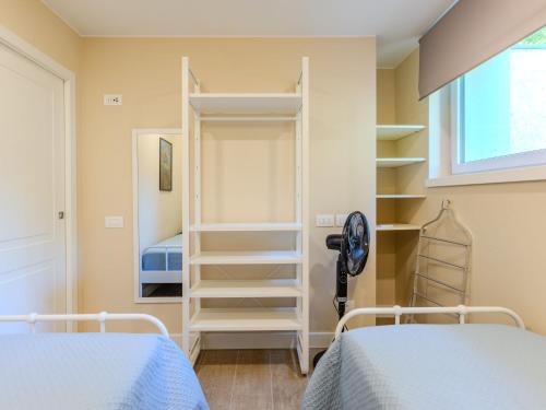 a bedroom with two beds and a closet at Apartment Riflesso del lago by Interhome in Gravedona