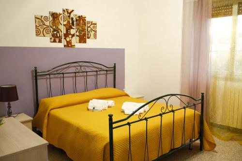 - une chambre avec un lit jaune et des serviettes dans l'établissement La casa di Francesca, à Matera