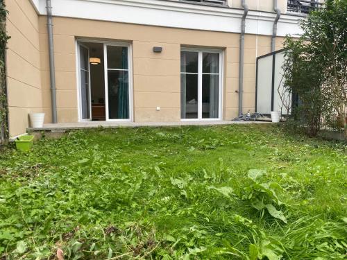 une maison avec une cour pleine de mauvaises herbes dans l'établissement Appart Delphine Montevrain, à Montévrain