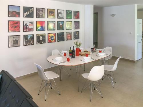 einen weißen Tisch mit weißen Stühlen und Gemälden an der Wand in der Unterkunft Holiday Home Villa Portobello Green by Interhome in Labin