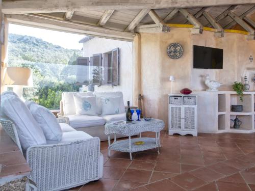 a living room with white furniture and a tv at Villa La Giulia Porto Cervo by Interhome in Arzachena