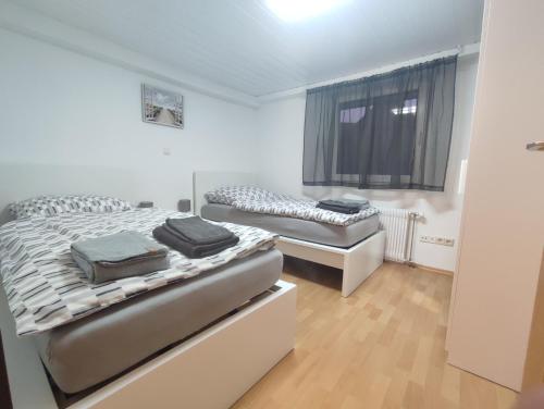 a bedroom with two beds and a window at Kaiserberg-Apartments "Auf dem Hohenstaufen" in Göppingen