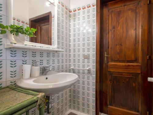 a bathroom with a sink and a wooden door at Villa La Giulia Porto Cervo by Interhome in Arzachena