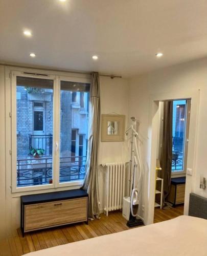 - une chambre avec une grande fenêtre donnant sur un bâtiment dans l'établissement Appartement Paris 15, à Paris