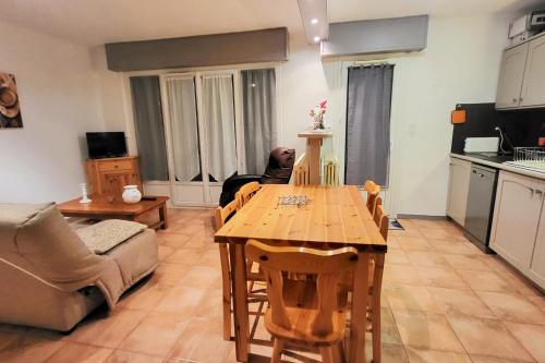 Il comprend un salon avec une table en bois et une cuisine. dans l'établissement 6-bed apartment close to the slopes, à Briançon