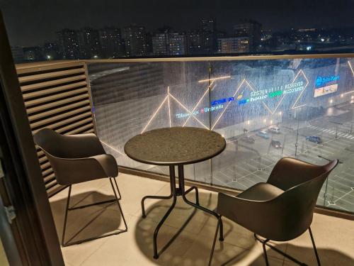 a table and chairs on a balcony with a view of a stadium at Planet Lux Apartment in Niš