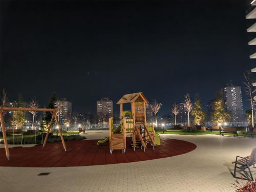 a playground in a park at night at Planet Lux Apartment in Niš