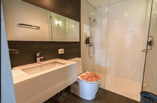 a bathroom with a sink and a shower and a toilet at 芭提雅日瓦达酒店式公寓 in Na Jomtien