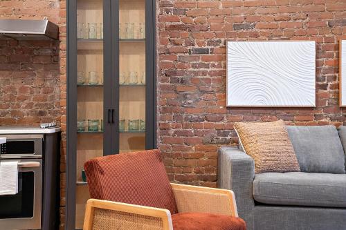 a living room with a couch and a brick wall at The Ontario Loft Suites in Montréal