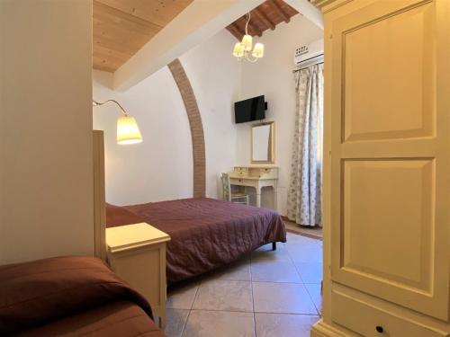 a room with two beds and a table and a door at Apartment Gufo-31 by Interhome in Podere Dottrina