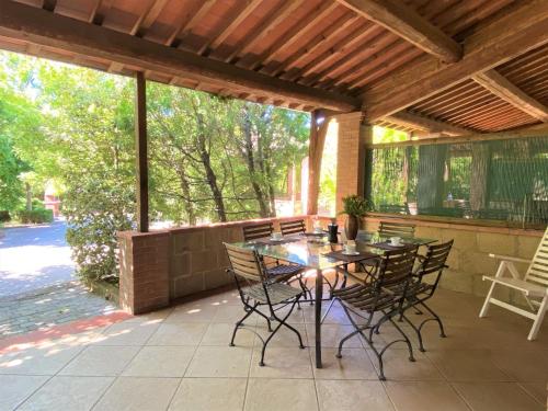 a wooden table and chairs on a patio at Apartment Gufo-31 by Interhome in Podere Dottrina