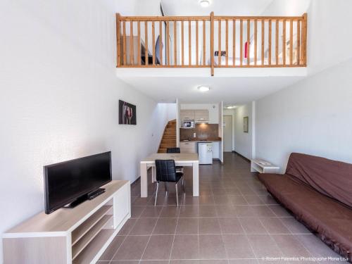 un salon avec un canapé et une télévision à écran plat dans l'établissement Holiday Home Domaine de Bacchus-Séjour-Galerie 4 pers by Interhome, à Saint-Christol