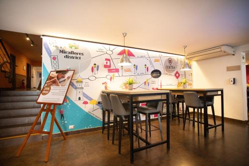 a room with tables and chairs in front of a wall at Centro by Casa Andina Miraflores in Lima
