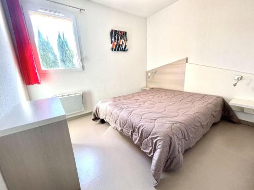 une chambre avec un lit dans une pièce avec une fenêtre dans l'établissement Holiday Home Domaine de Bacchus-Séjour-Galerie 4 pers by Interhome, à Saint-Christol