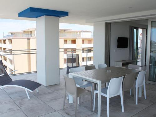 Apartment Nashira-6 by Interhome في لينانو سابيادورو: غرفة طعام مع طاولة وكراسي على شرفة