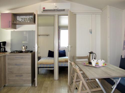 a small kitchen and dining room with a table in a room at Holiday Home Happy Premium by Interhome in Rosapineta