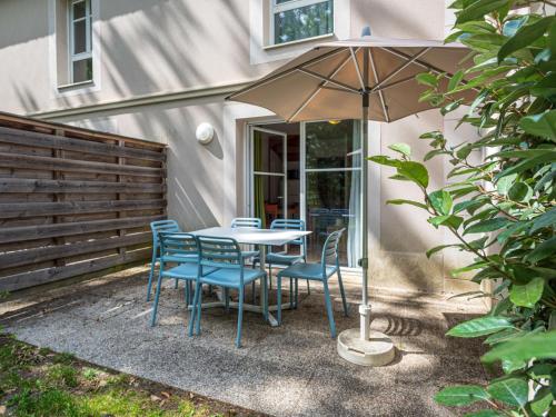 - une table et des chaises avec un parasol dans la cour dans l'établissement Holiday Home Cottage Privilège - SUM103 by Interhome, à Saumur