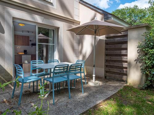 une table et des chaises avec un parasol dans une cour arrière dans l'établissement Holiday Home Cottage Privilège - SUM103 by Interhome, à Saumur