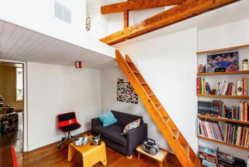 un salon avec un canapé et une étagère dans l'établissement Votre suite entre Belleville et Canal, à Paris