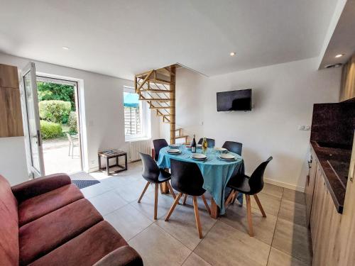 un salon avec une table avec des chaises et un canapé dans l'établissement Holiday Home T4-Résidence La Carquois by Interhome, à Fréhel