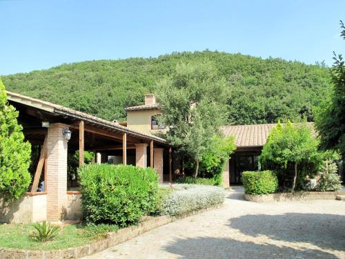 una casa con una montaña al fondo en Apartment Istrice-30 by Interhome, en Riparbella