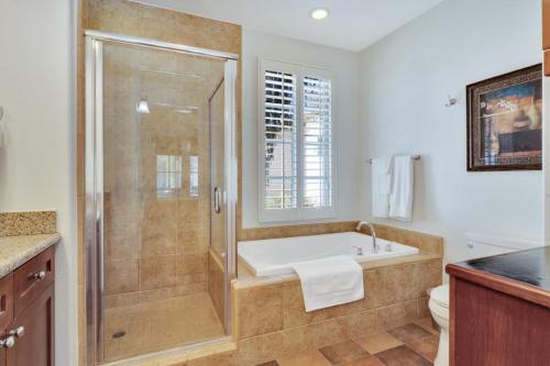 a bathroom with a bath tub and a shower at Tranquil Ground Floor Villa in Heart of LQ #A in La Quinta