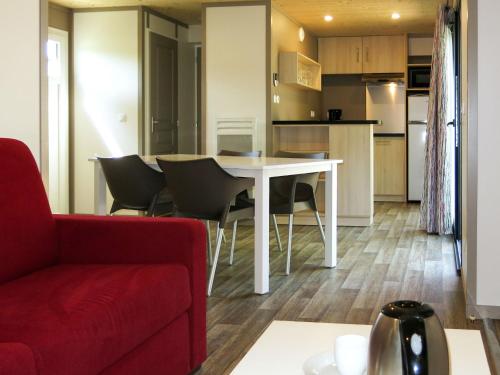 Il comprend un salon et une cuisine avec une table et des chaises. dans l'établissement Holiday Home Le Moulin Neuf- 4-6 personnes by Interhome, à Rochefort-en-Terre