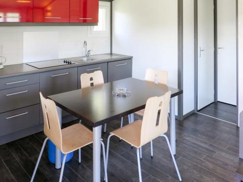 - une cuisine avec une table, des chaises et un évier dans l'établissement Holiday Home Les Hameaux de Pomette-Chalet 6 pers- by Interhome, à Le Pit