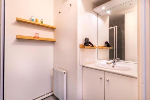 une salle de bain avec un lavabo et un miroir dans l'établissement Mail Pablo Picasso BIS -Parking, à Nantes