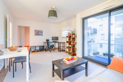 un salon avec une grande fenêtre et une table dans l'établissement Mail Pablo Picasso BIS -Parking, à Nantes