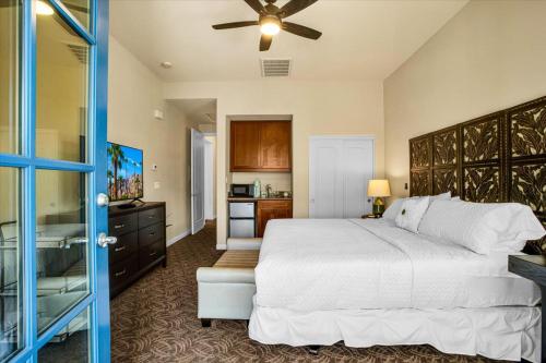 a bedroom with a large white bed and a kitchen at Relax & Recharge at this 2BR Desert Villa in La Quinta