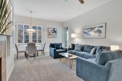 a living room with a blue couch and a table at Newly Remodeled Desert Getaway #A in La Quinta