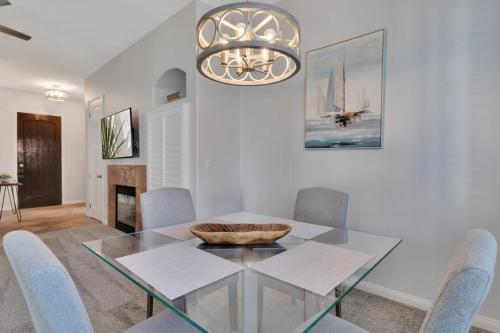 a dining room with a glass table and chairs at Newly Remodeled Desert Getaway #A in La Quinta