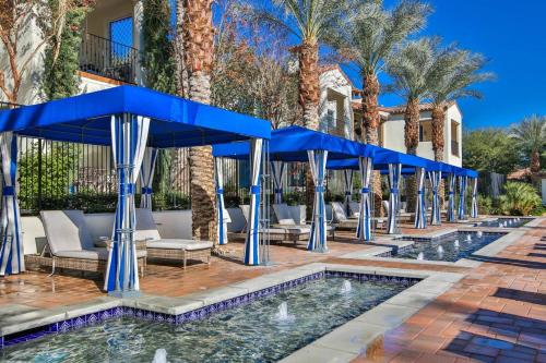 a resort with a pool with blue umbrellas at Newly Remodeled Desert Getaway #A in La Quinta
