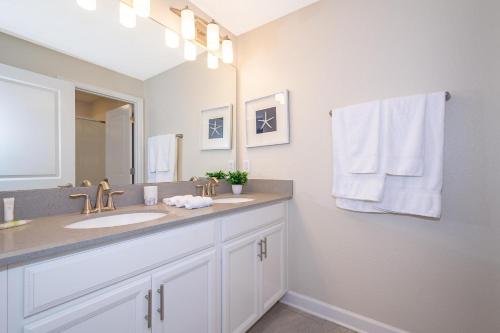 a bathroom with a sink and a mirror at 4809AM TOWNHOUSE 4 BEDROOMS & 3 BATHROOMS + POOL in Kissimmee