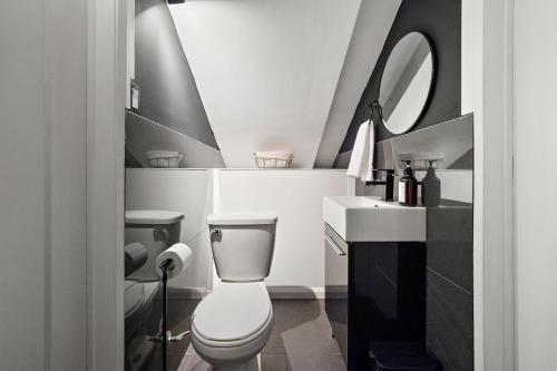 a bathroom with a toilet and a sink and a mirror at The Ontario Loft Suites in Montréal