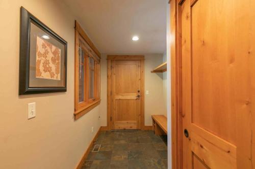a hallway with a wooden door and a wooden bench at Fairway Drive 13151 by East West Hospitality in Truckee