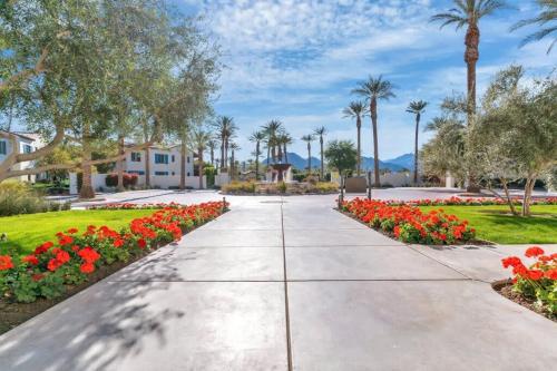 a walkway through a park with flowers and palm trees at Spectacular Desert Retreat in La Quinta #A in La Quinta