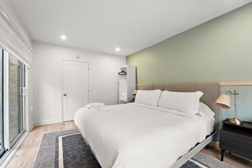a bedroom with a large white bed and a window at The Ontario Loft Suites in Montréal