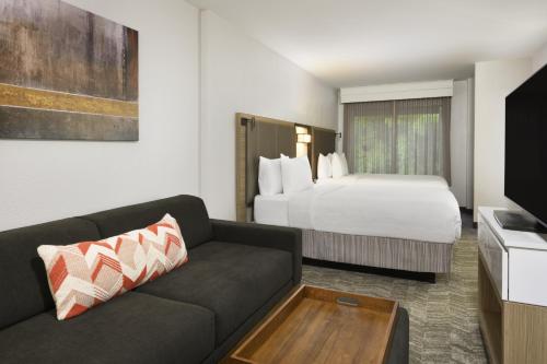 a hotel room with a couch and a bed at SpringHill Suites by Marriott Newnan in Newnan