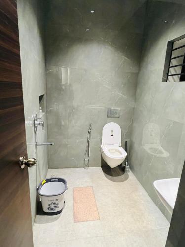 a bathroom with a toilet and a sink at WHITE COTTAGE- Deluxe villa in Udupi