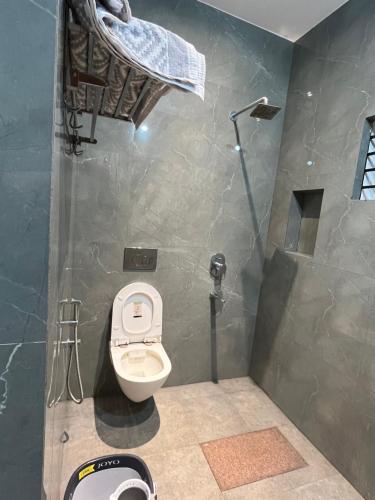 a bathroom with a toilet and a shower at WHITE COTTAGE- Deluxe villa in Udupi