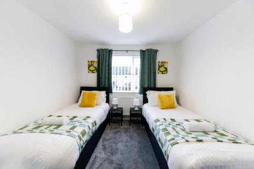two beds in a room with green curtains at Spacious 2Bed - Great for Contractors - Driveway&Garden in Pallion