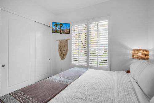 a white bedroom with a bed and a window at Revitalized Desert Getaway #A in La Quinta