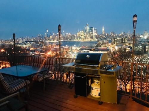 a grill on a balcony with a view of a city at Stunning Empire State 3 BR'S in Union City