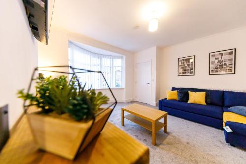 a living room with a blue couch and a table at Spacious 2Bed - Great for Contractors - Driveway&Garden in Pallion