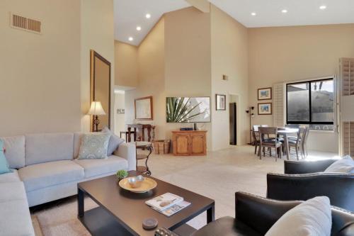a living room with a couch and a table at Spacious Villa with Spectacular Golf Course Views in La Quinta