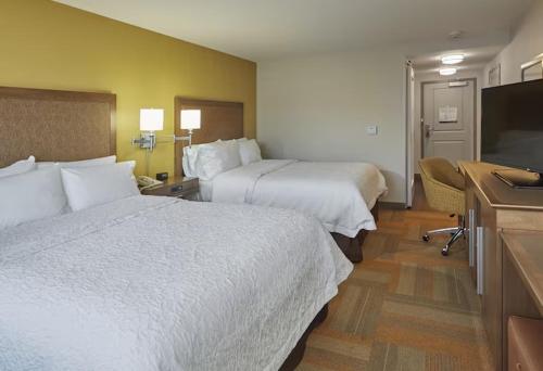 a hotel room with two beds and a flat screen tv at Hampton Inn & Suites Hood River in Hood River