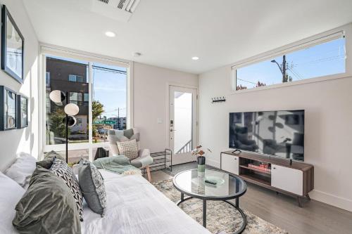 a living room with a white couch and a tv at Perch - Dayton Dream in Seattle