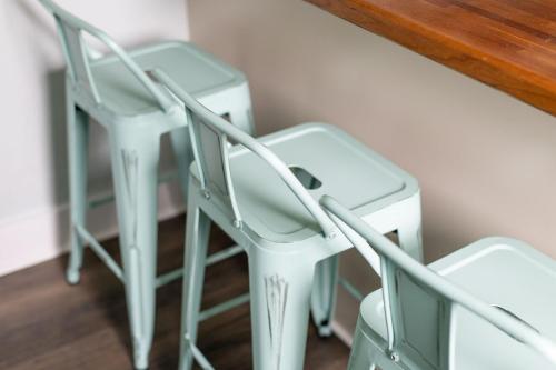 two white stools next to a counter with a table at Lakeside Retreat in Orono, Maine in Orono